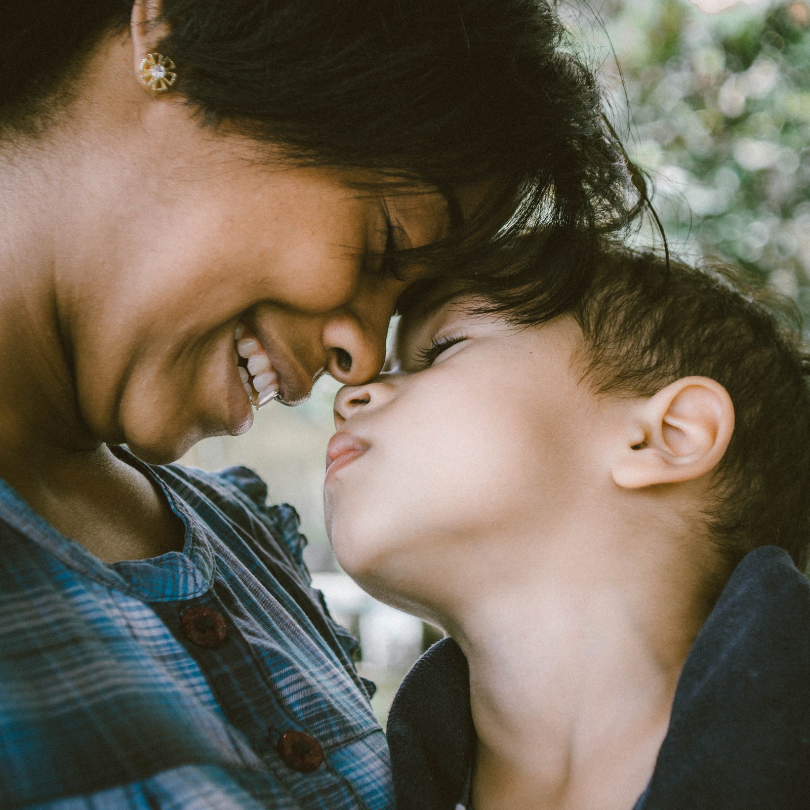 a mother kissing his kid
